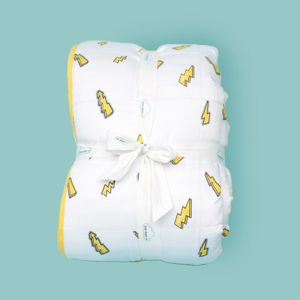Yellow cartoon style lightning bolts, on white background quilted blanket, folded, on an aqua background
