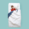 Boy in bed with dinosaur quilted blanket covering him to show double size